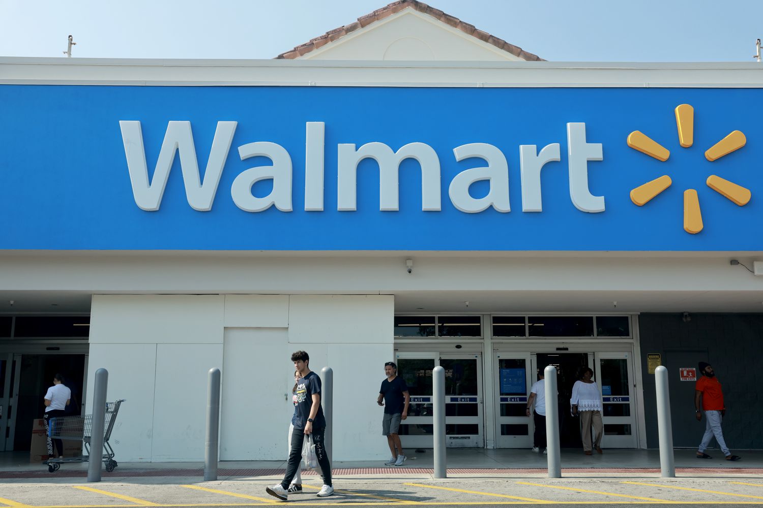 People walk near the entrance to a Walmart store on May 14, 2024, in Miami