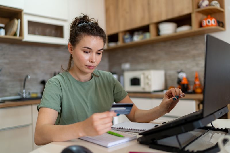 Young woman paying off her credit card debt on her laptop.