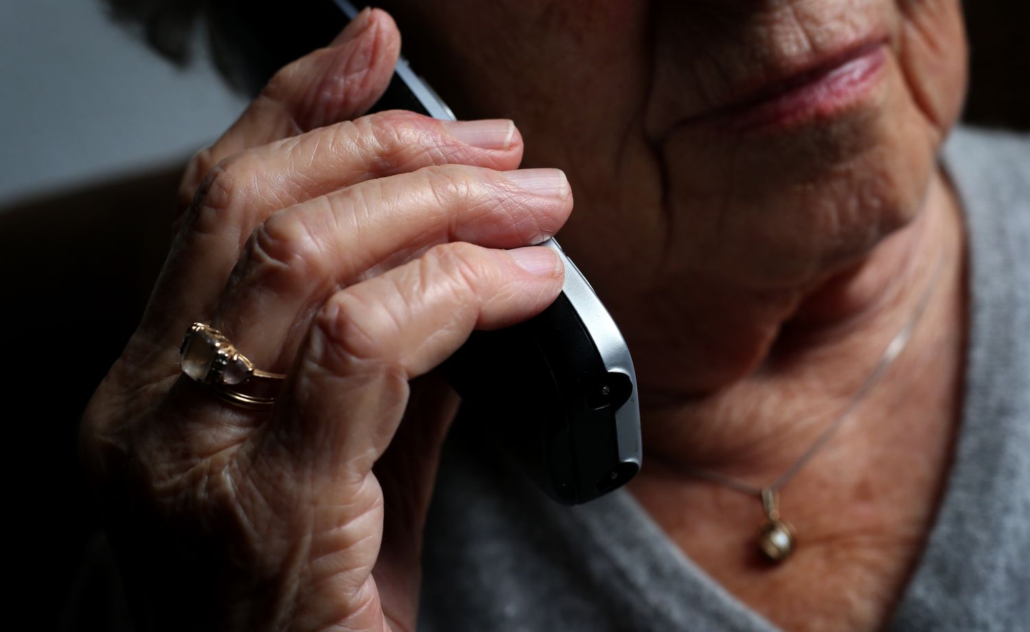 An older woman holding a cell phone to her ear.
