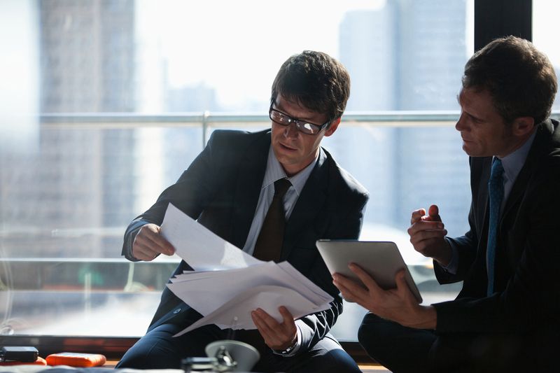 Two executives review documents in an office.