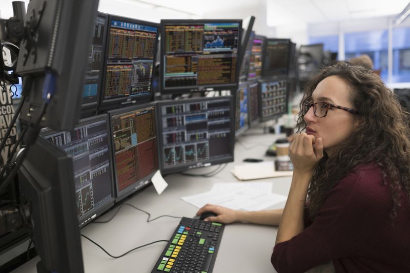 Trader looking at several monitors