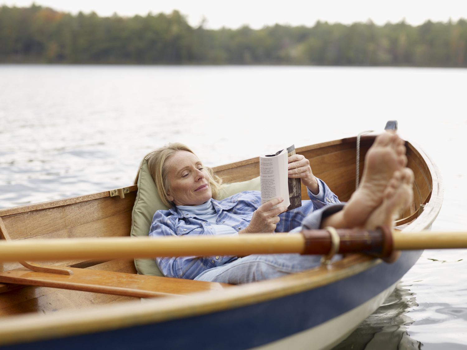 Older woman reading in a rowboat