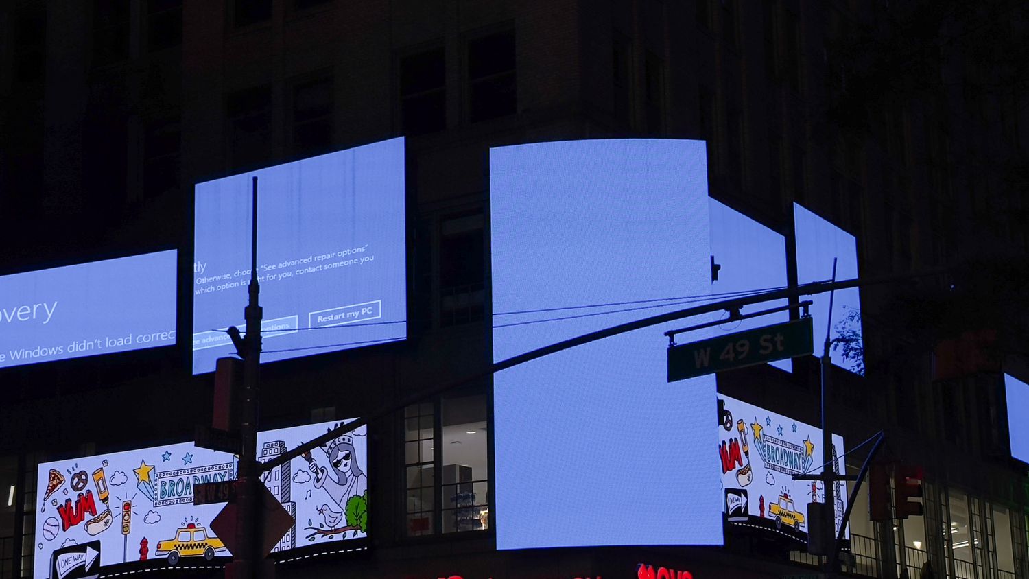 Times Square digital billboards show a Windows error message after a CrowdStrike update caused a global tech outage. 