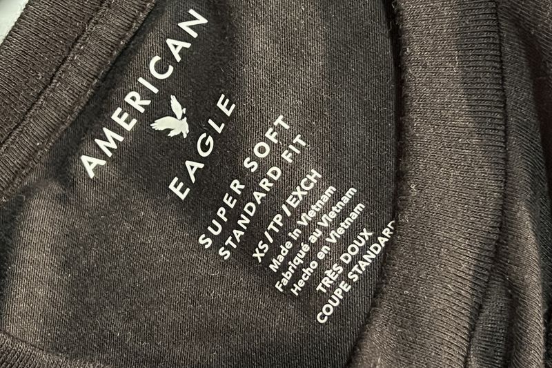 The inside of a black shirt says "American Eagle, Super Soft Standard Fit" with other size and manufacturing information.