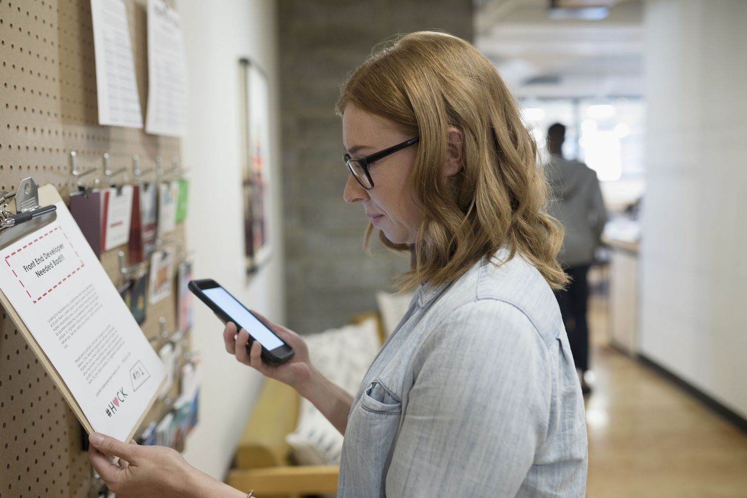 Freelancer checks smart phone in an office