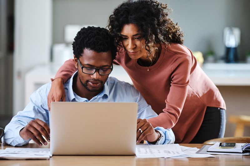 Cropped shot of a young married couple working on their financial budget together in the kitchen at home