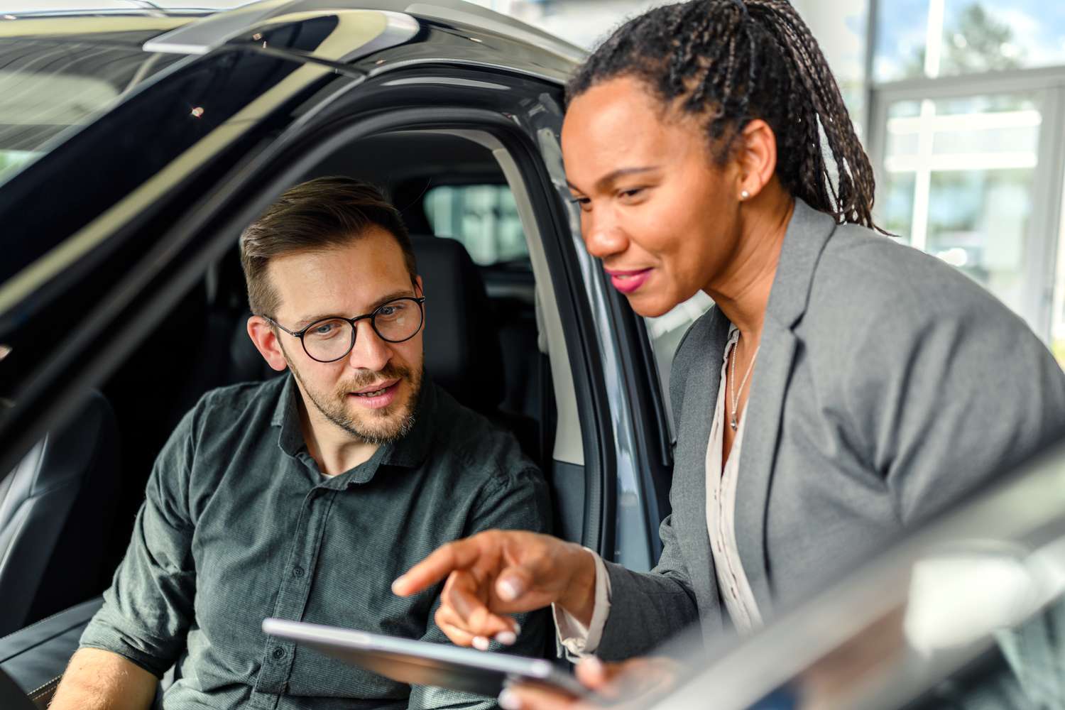Man discussing with a car dealer whether he should get an extended warranty with his auto loan