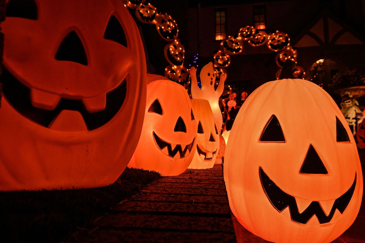 Halloween decorations including lit-up ghosts and pumpkins appear outside a home in California.