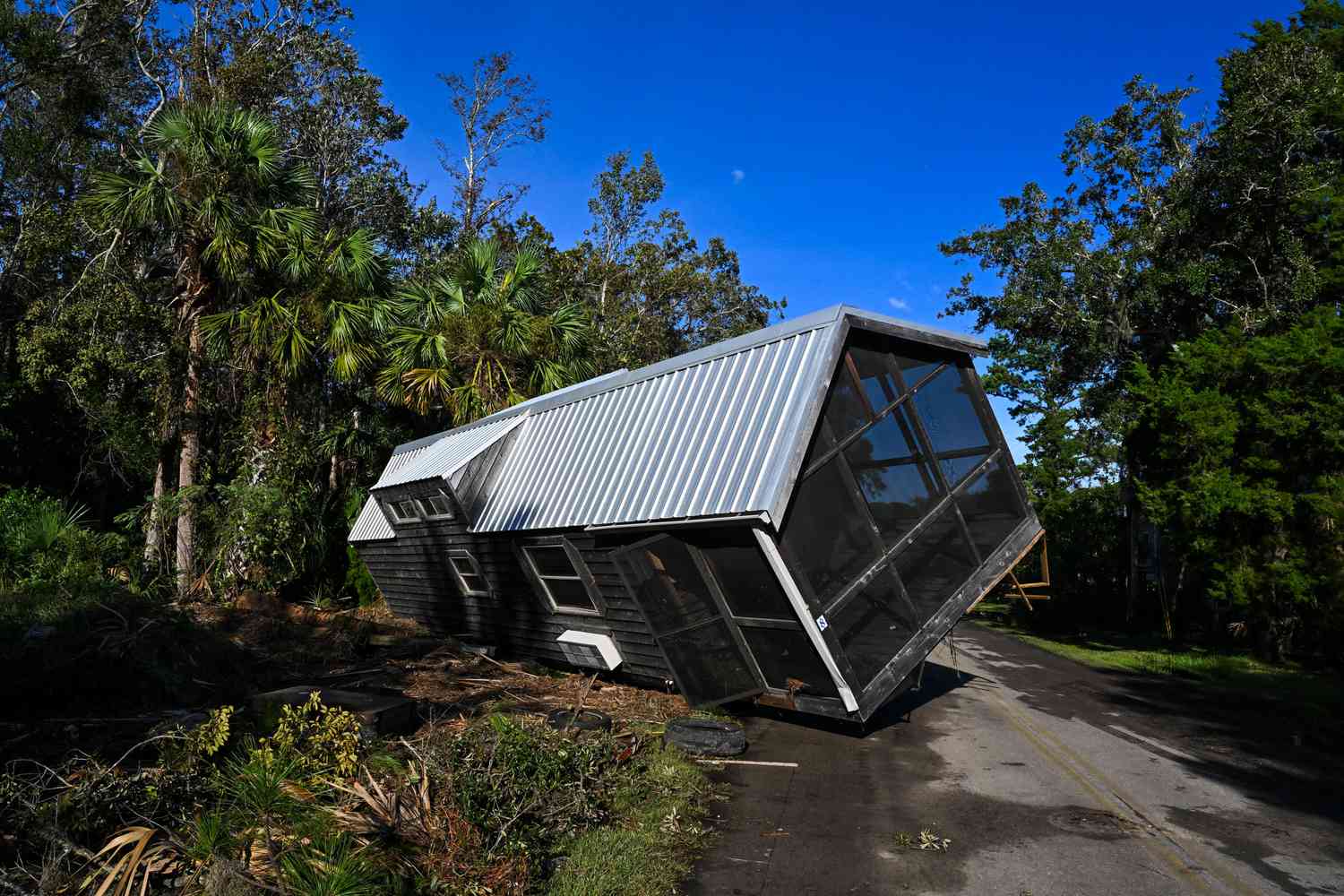A displaced damaged mobilhome is seen in the middle of a road in Steinhatchee, Florida on August 30, 2023 after Hurricane Idalia made landfall. Idalia slammed into northwest Florida as an "extremely dangerous" Category 3 storm early Wednesday, buffeting coastal communities with cascades of water as officials warned of "catastrophic" flooding in parts of the southern US state.