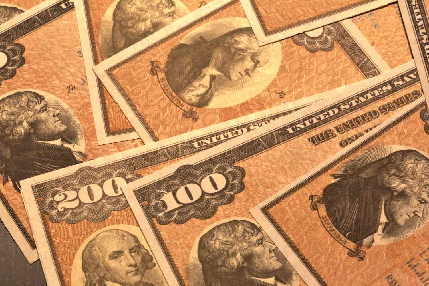 A close up of an assortment of U.S. Savings bonds scattered on a surface.
