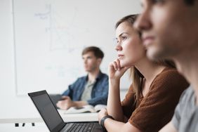 Student listening in college classroom.