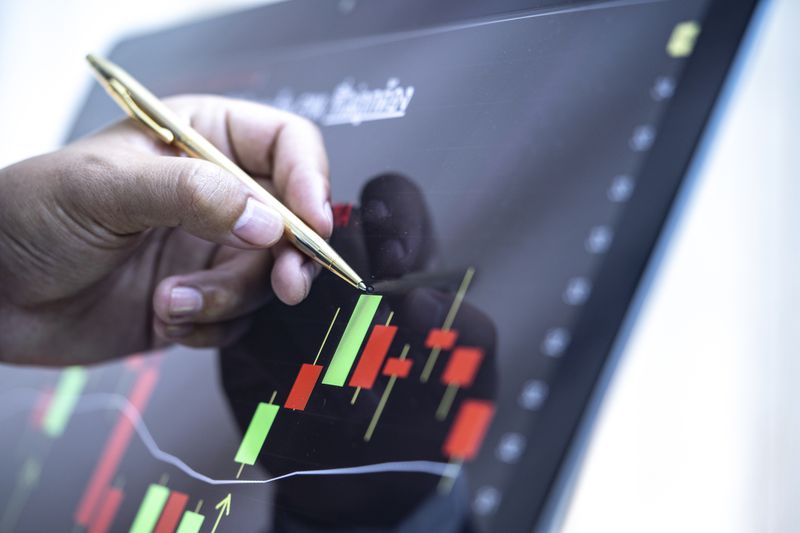 A man pointing a laptop screen with a pen.
