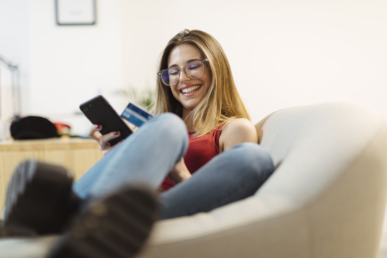 Woman using a credit card and a cell phone