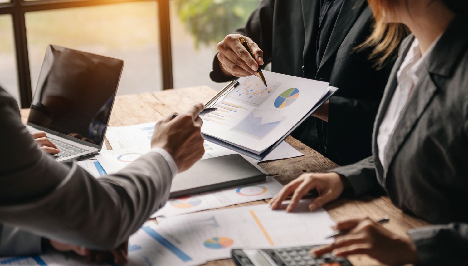 Three fund managers discussing financial documents