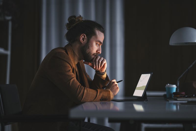 A man looks at his mutual fund investments on his tablet at home at night