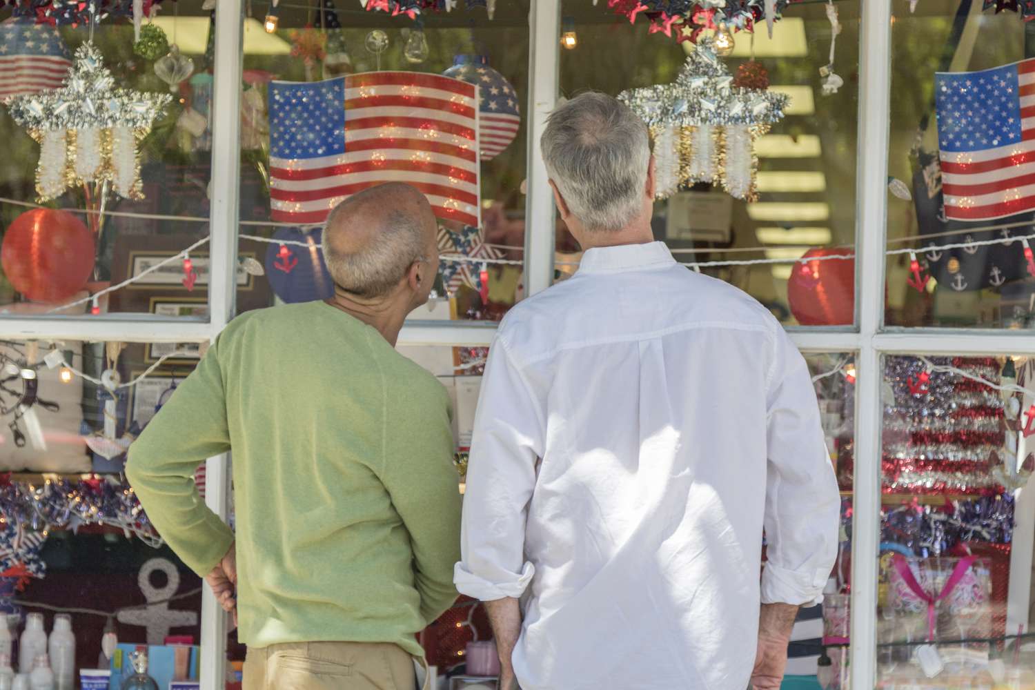 Two people looking at 4th of July merchandise in a store window