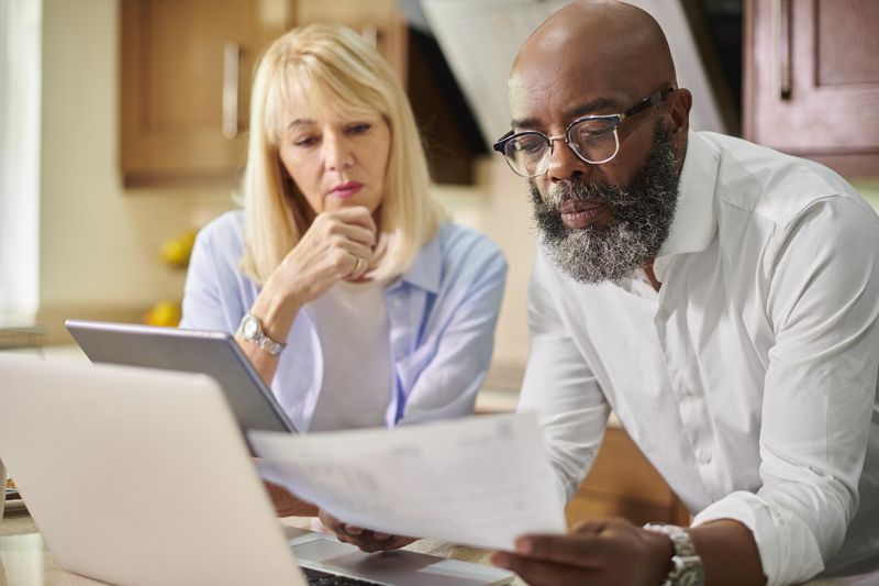 Older couple looking over the paperwork needed to refinance their home