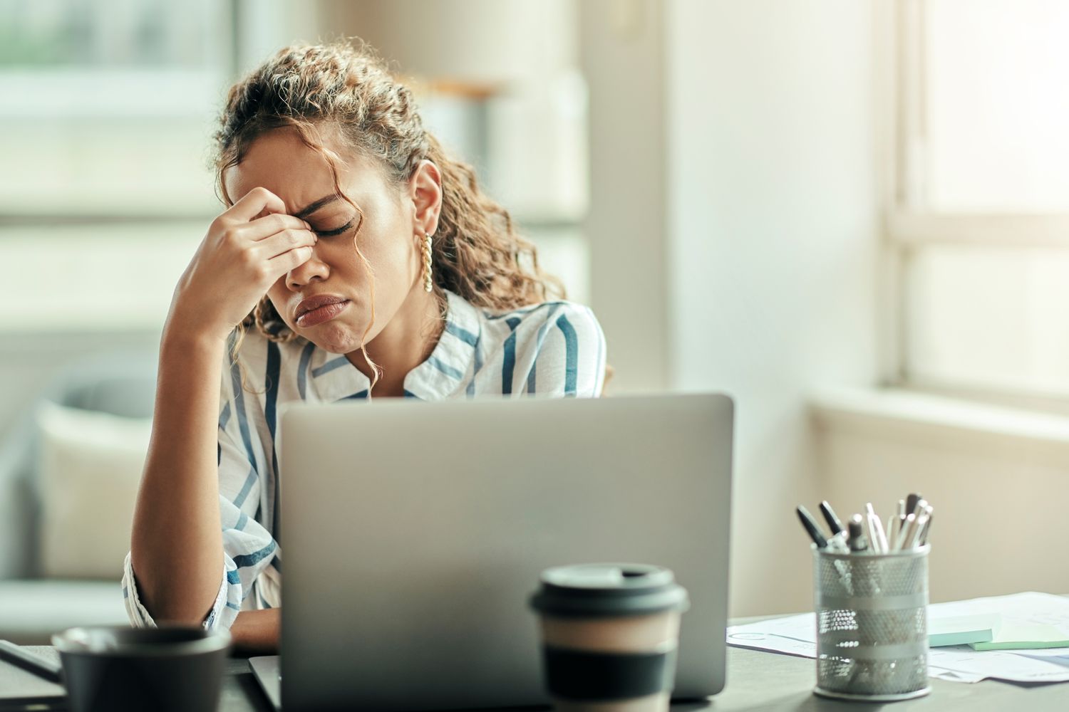 A stressed out stock trader pinches the bridge of their nose after seeing that the SEC has suspended trading in one of their stocks.