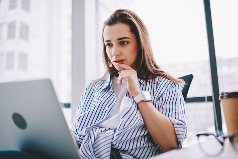 Woman in her 20s or 30s looking intently at something on her laptop
