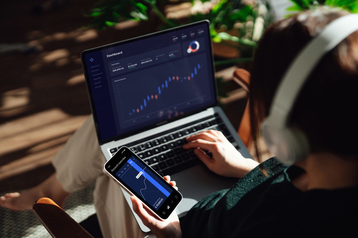 Over the shoulder view of someone managing stocks and cryptocurrencies.