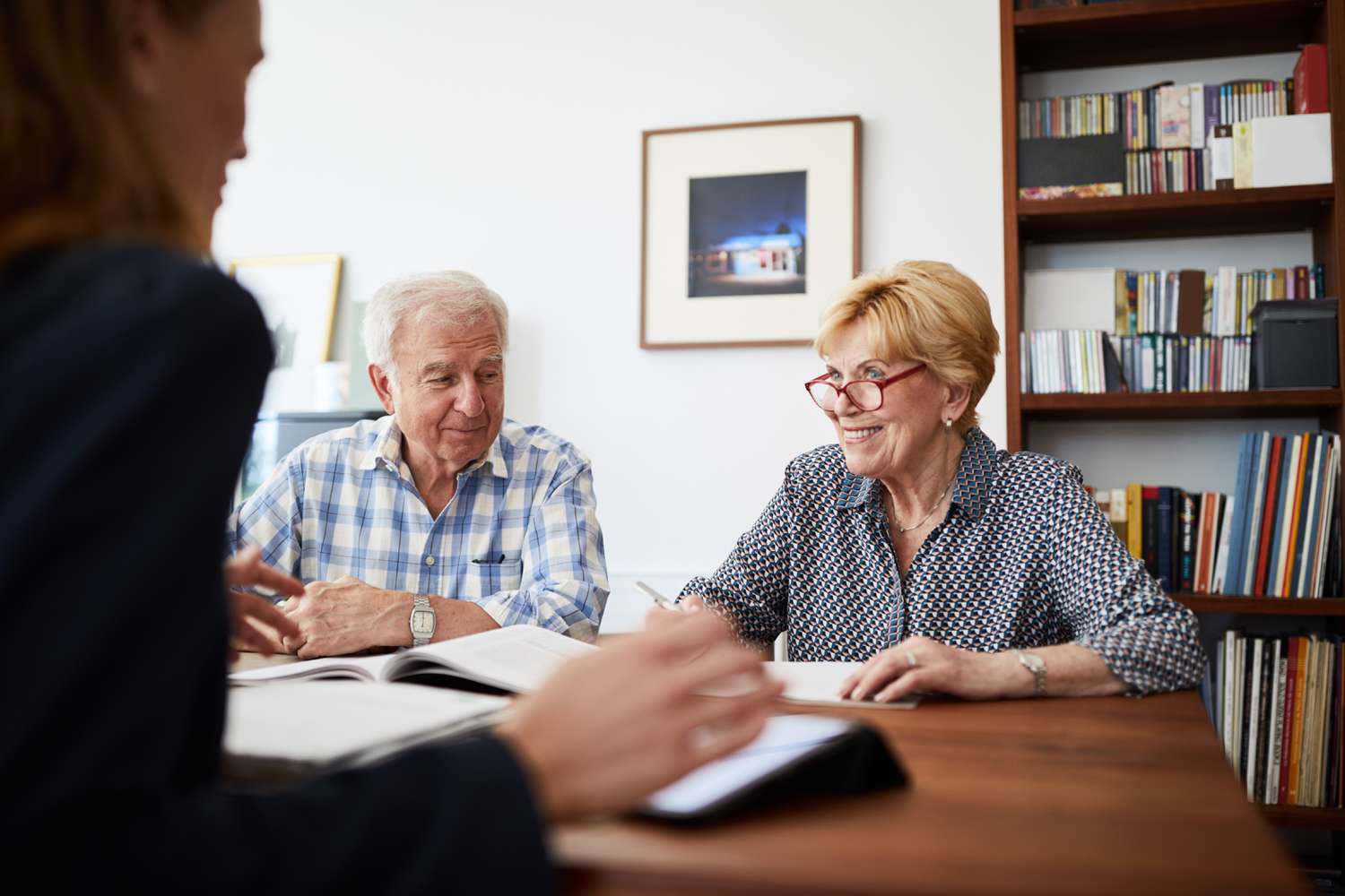 Senior couple planning their investments with financial advisor. Retired couple meeting with a female financial advisor at home.