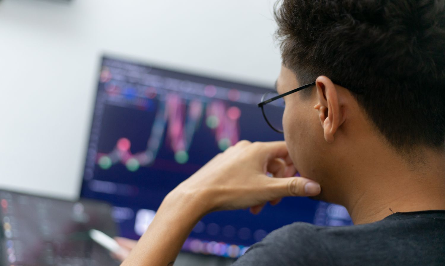 Young man analyzing a candlestick chart. 