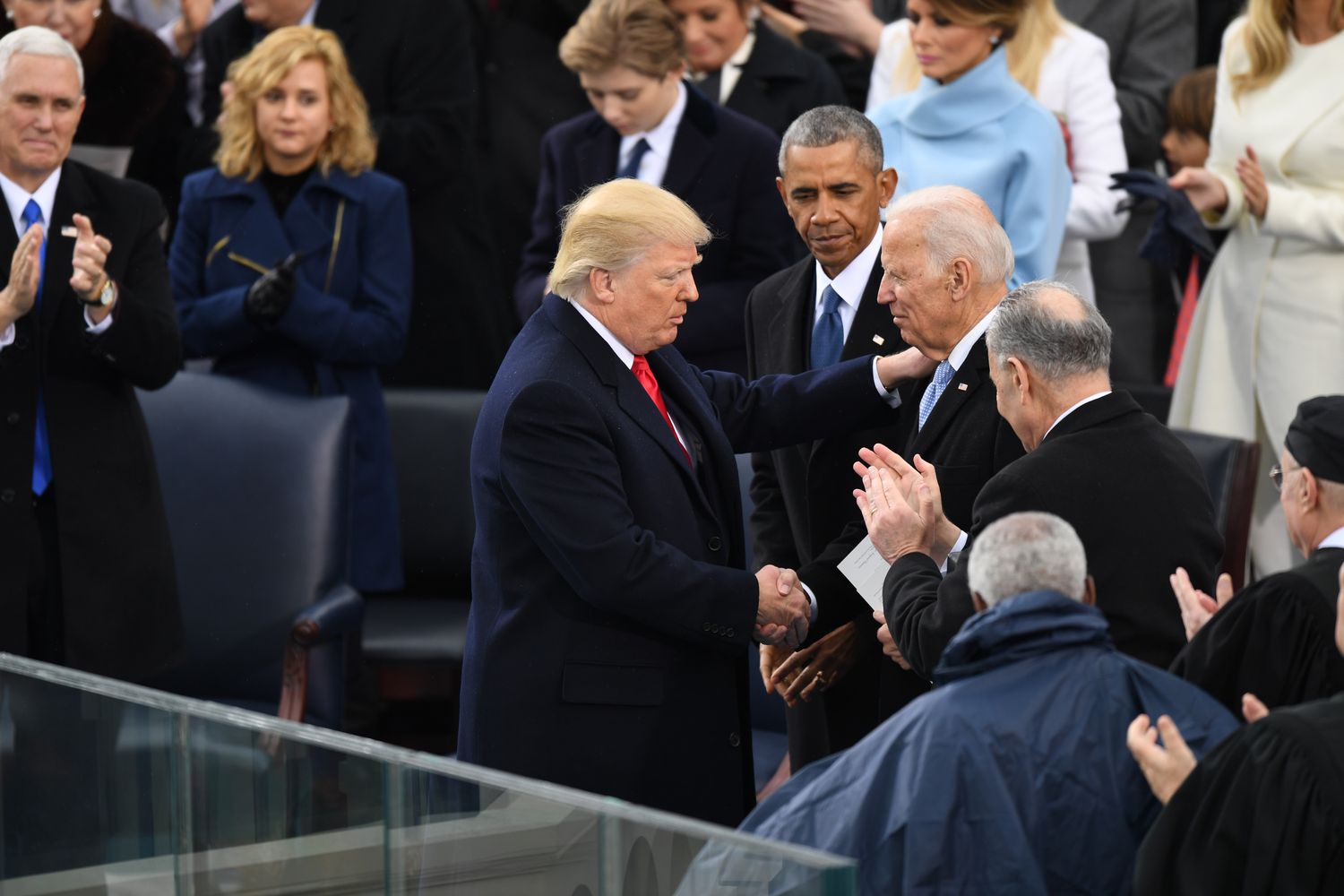 President Donald J. Trump shakes hands with Former vice president Joe Biden as Former president Barack Obama looks on at the inauguration of President Donald J. Trump on January 20, 2017.