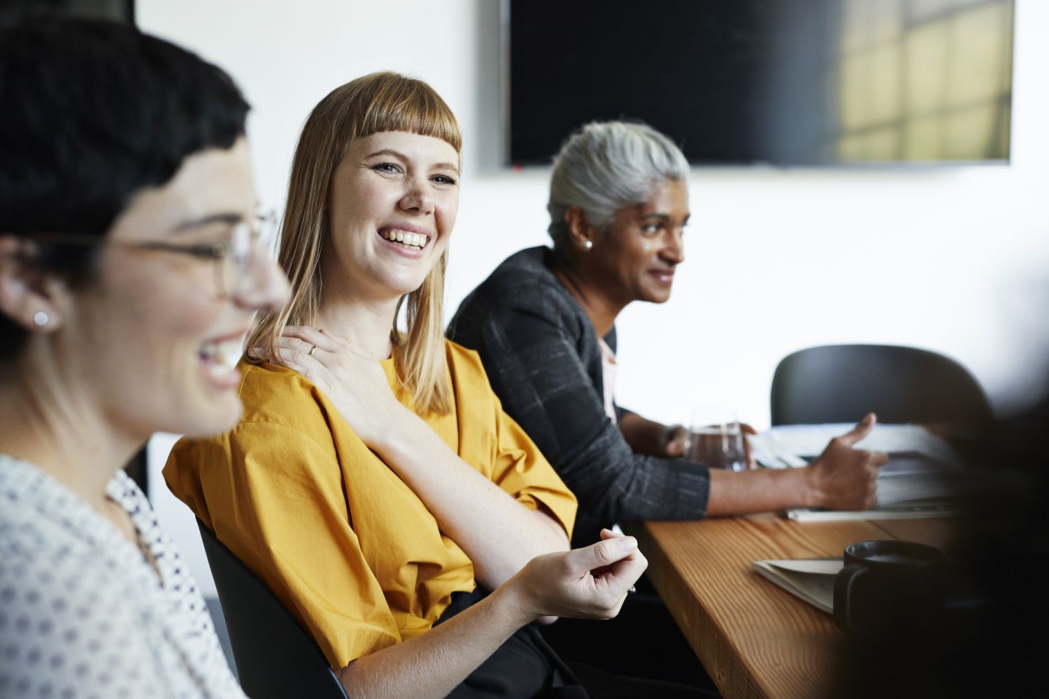 Coworkers discuss their 401(k) program at work during an HR meeting.