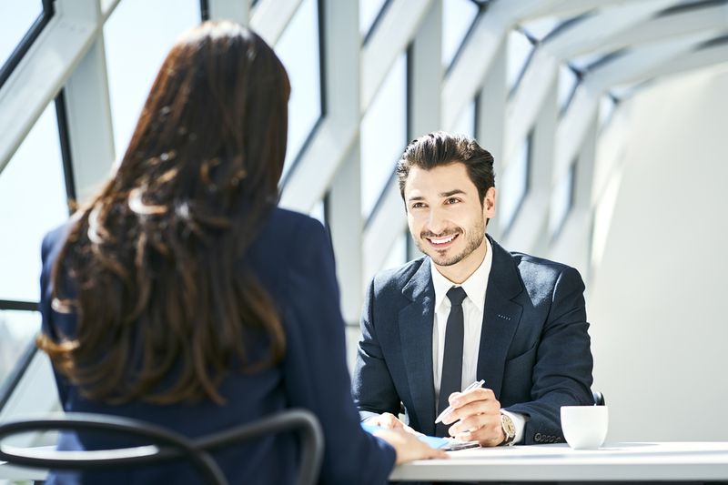 Smiling Businessman Looking at Businesswoman in Modern Office