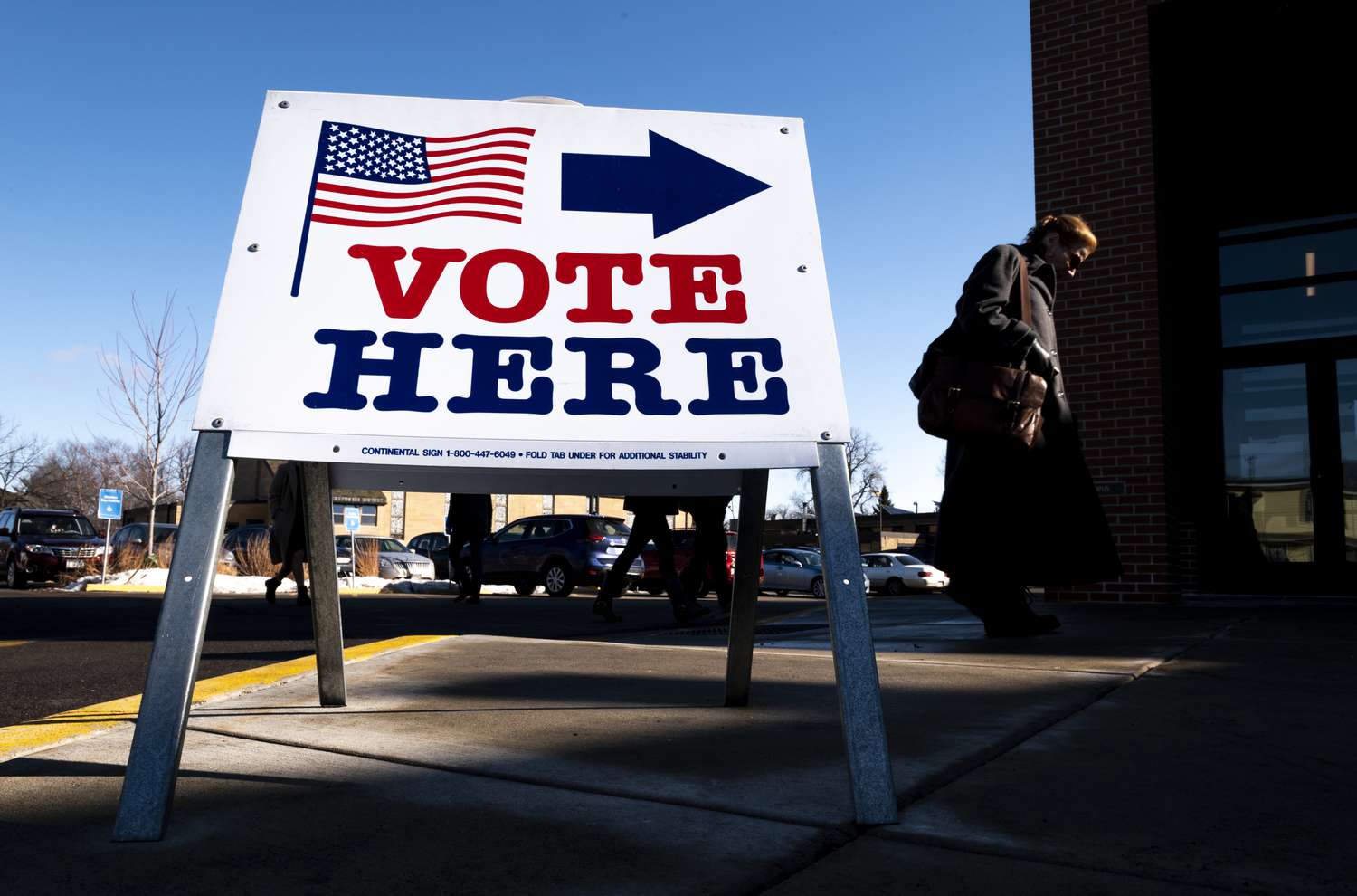 A sign reading "vote here" outside of a polling place. 