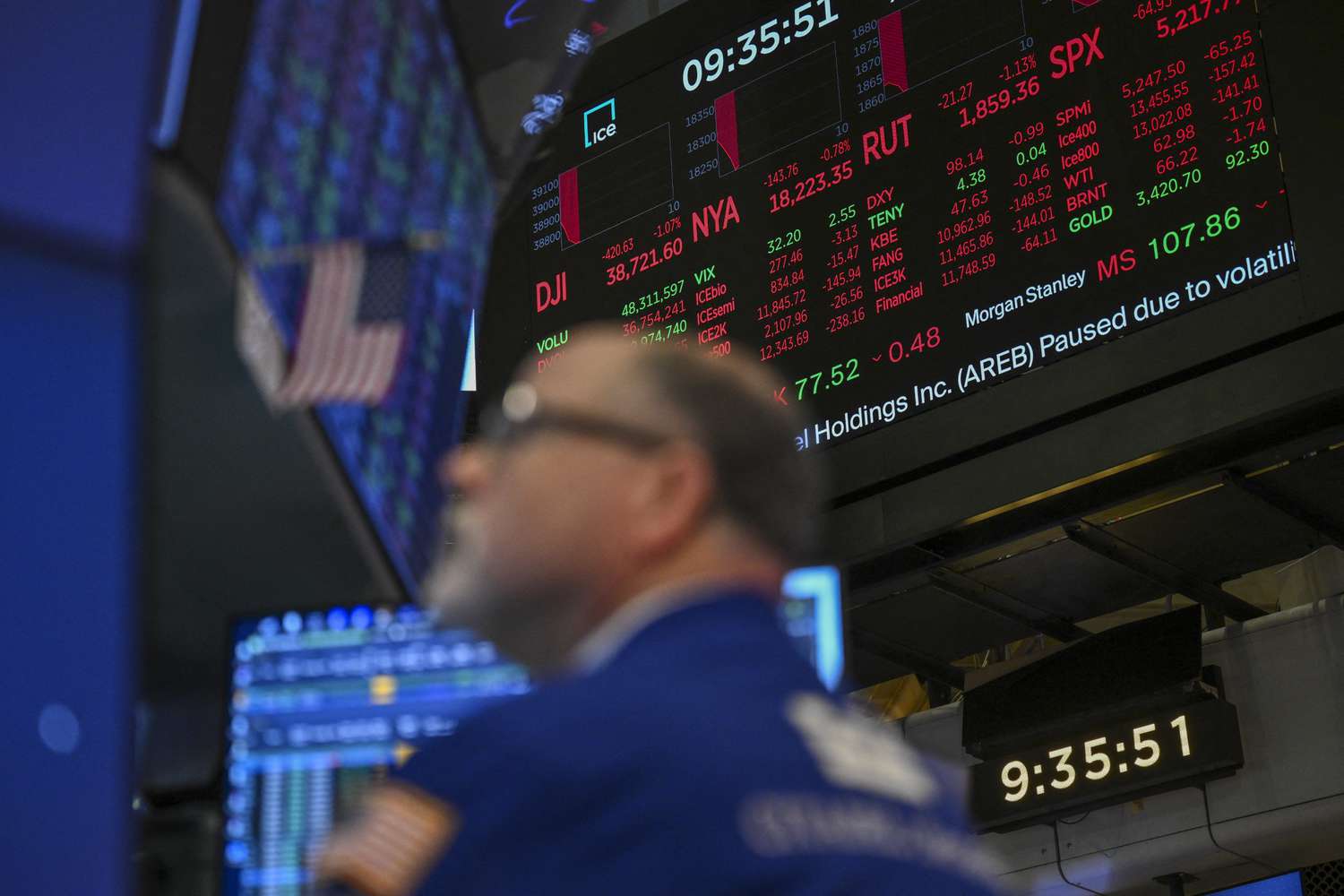 Stock market statistics are displayed as traders work on the floor of the New York Stock Exchange 