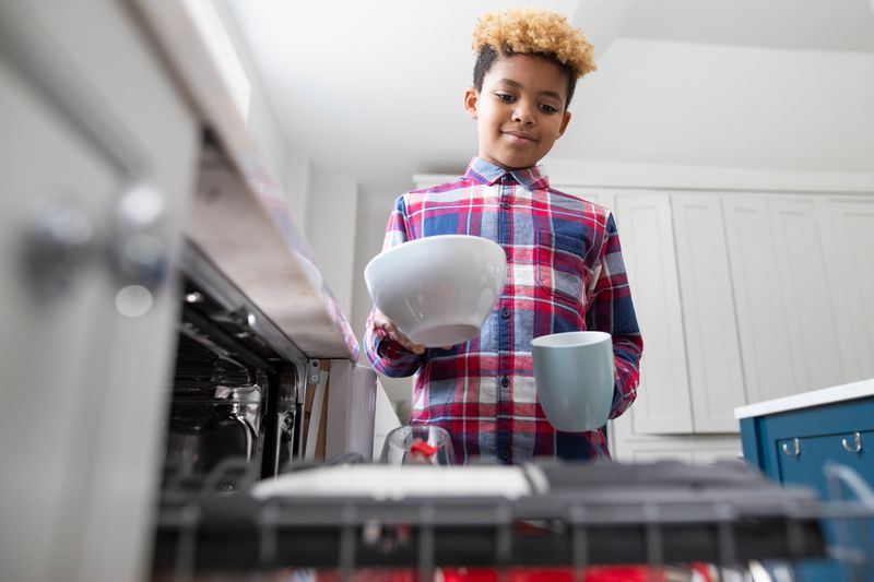 Child loading up dishwasher