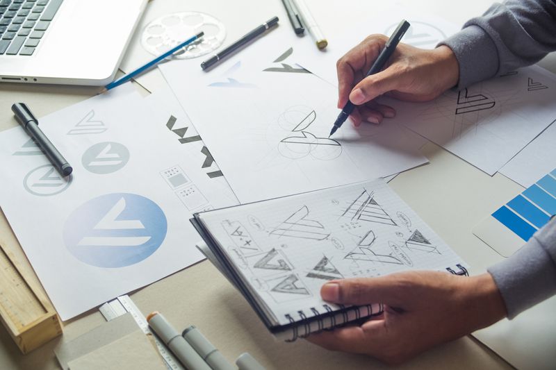 Graphic designer drawing sketch design creative Ideas draft Logo product trademark label brand artwork. Graphic designer studio Concept.