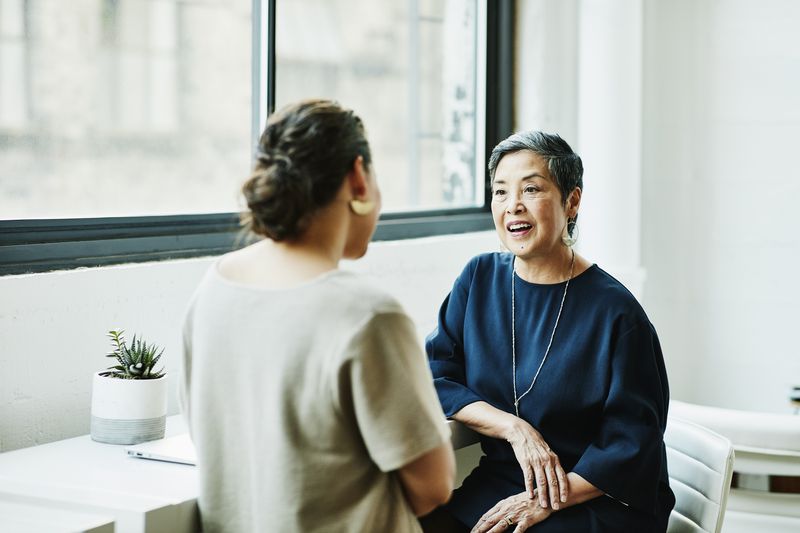 Two women facing each other and having a discussion