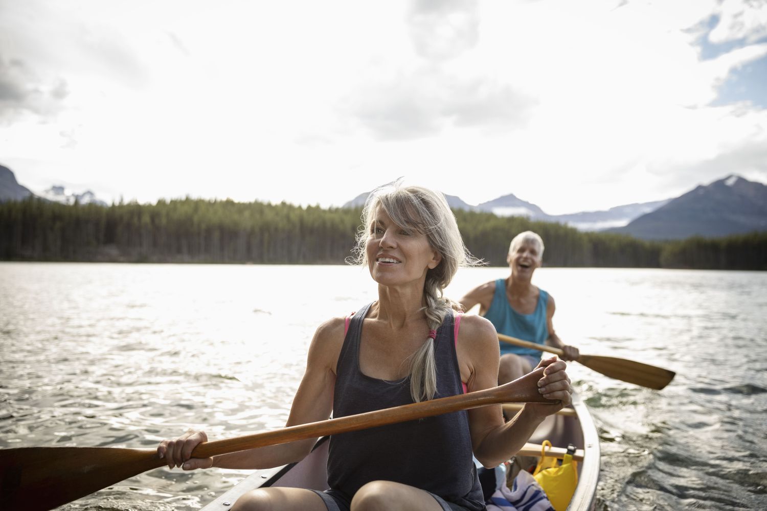 Mature couple canoeing on tranquil lake in Alberta, Canada