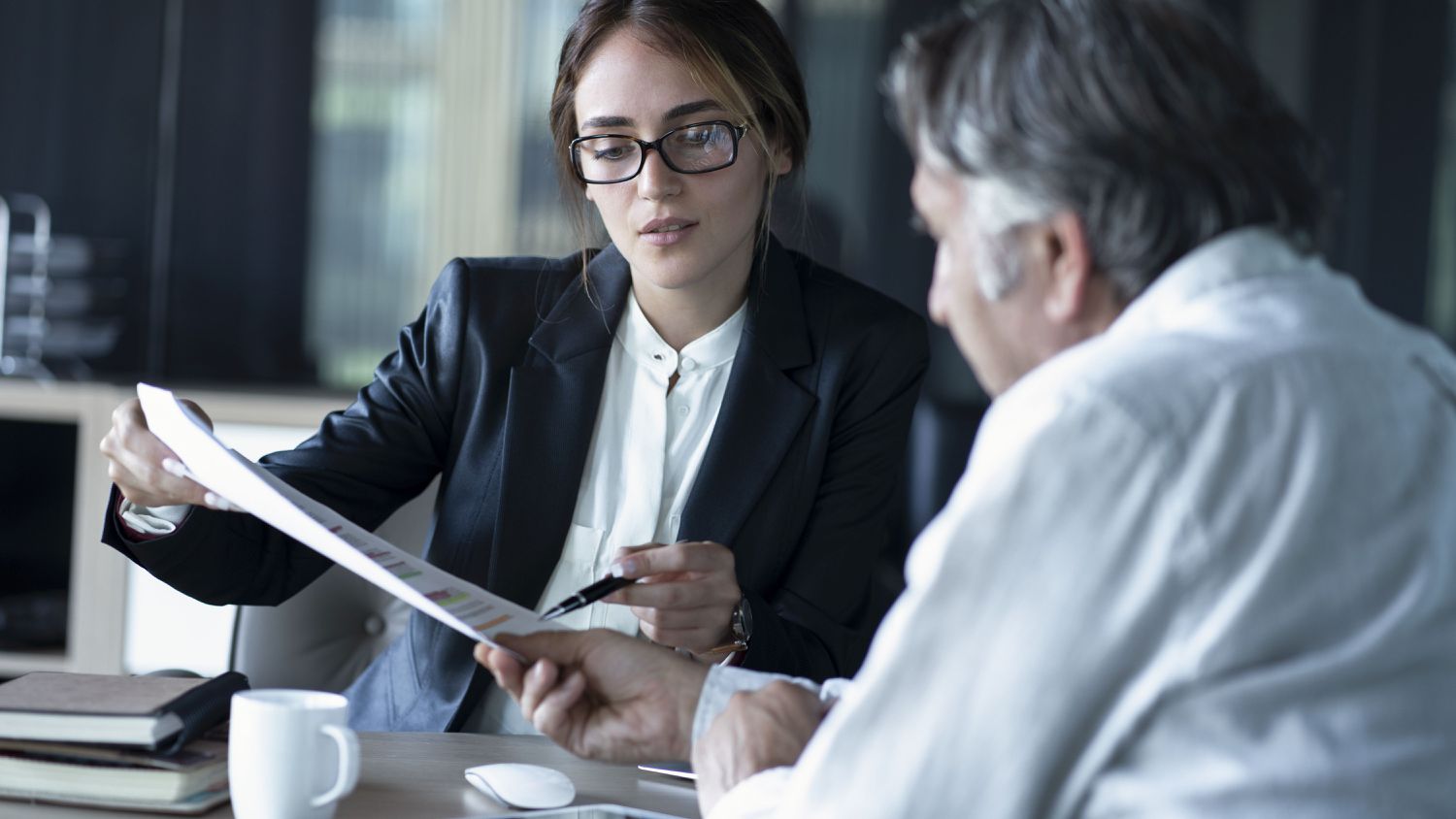 Two people looking at paperwork in a meeting