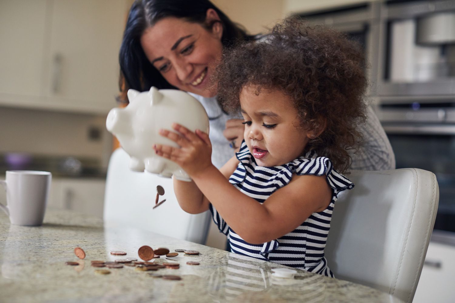Parent and child getting money from a piggy bank