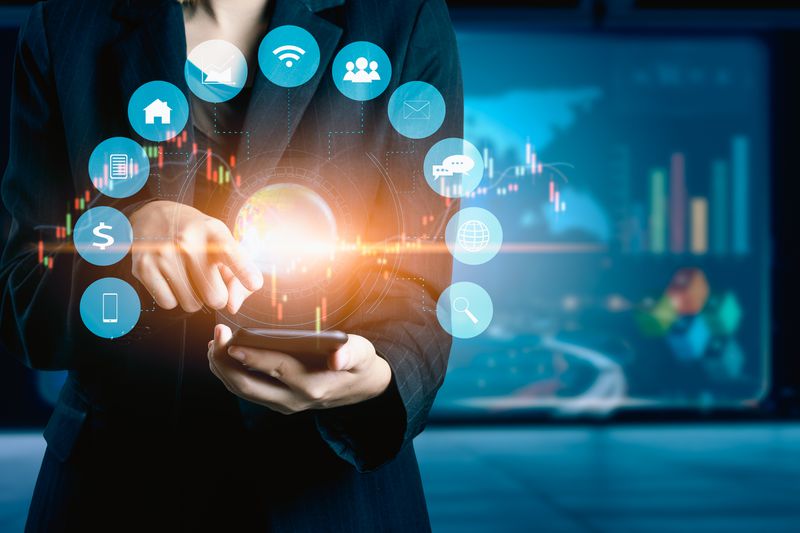 A businesswomen using mobile phone analyzing data and economic growth graph chart.