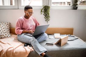 Person with glasses working on a laptop