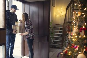 A teenager receiving Christmas packages delivered by postman.