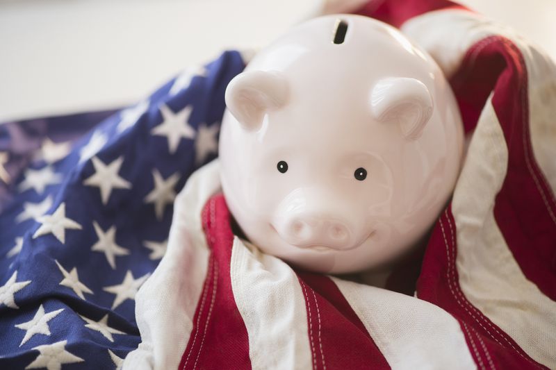 Close up of piggy bank and US flag