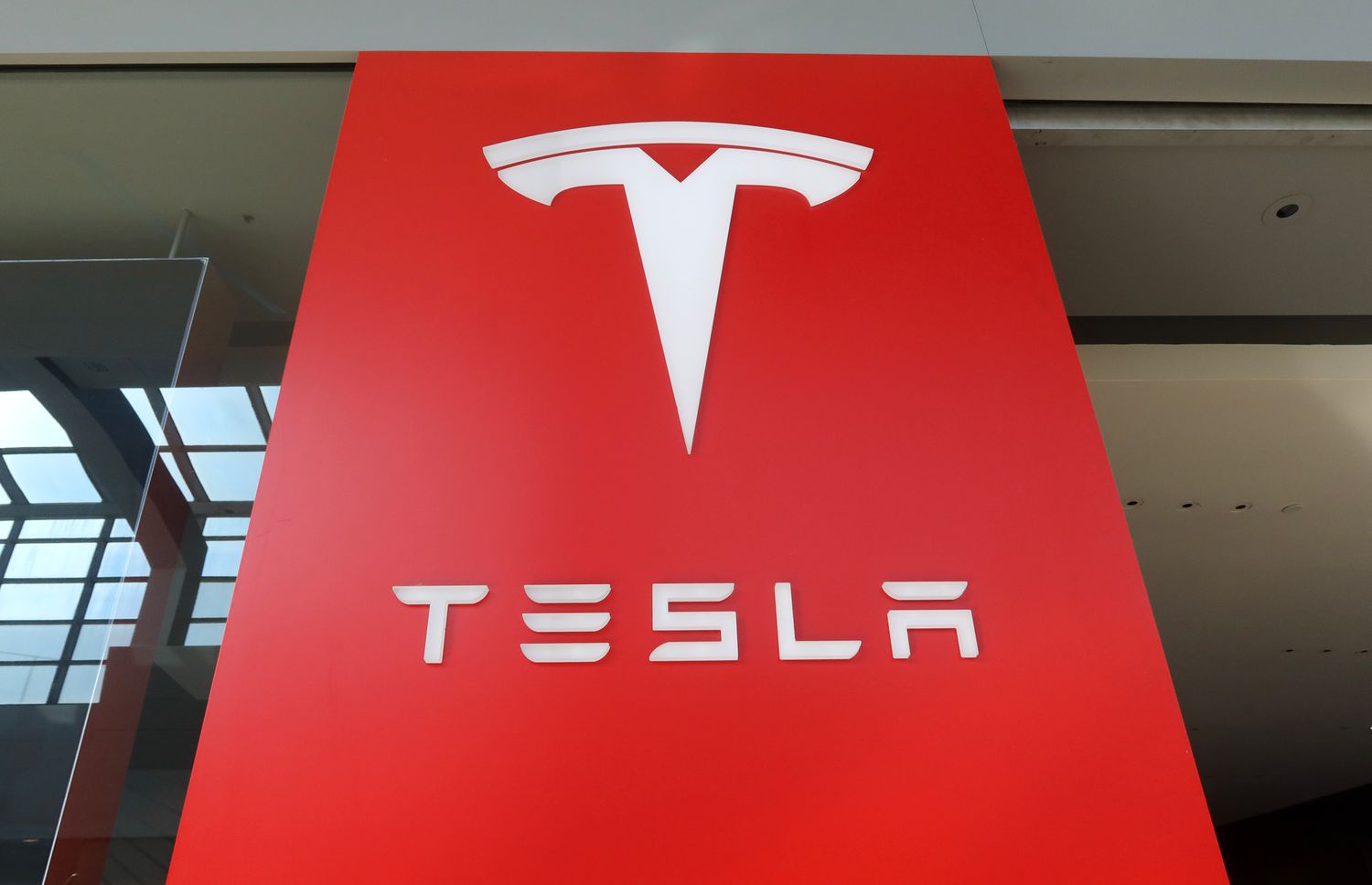 A Tesla corporate logo sits above the entrance to their store at the Garden State Plaza Mall on October 26, 2024, in Paramus, New Jersey