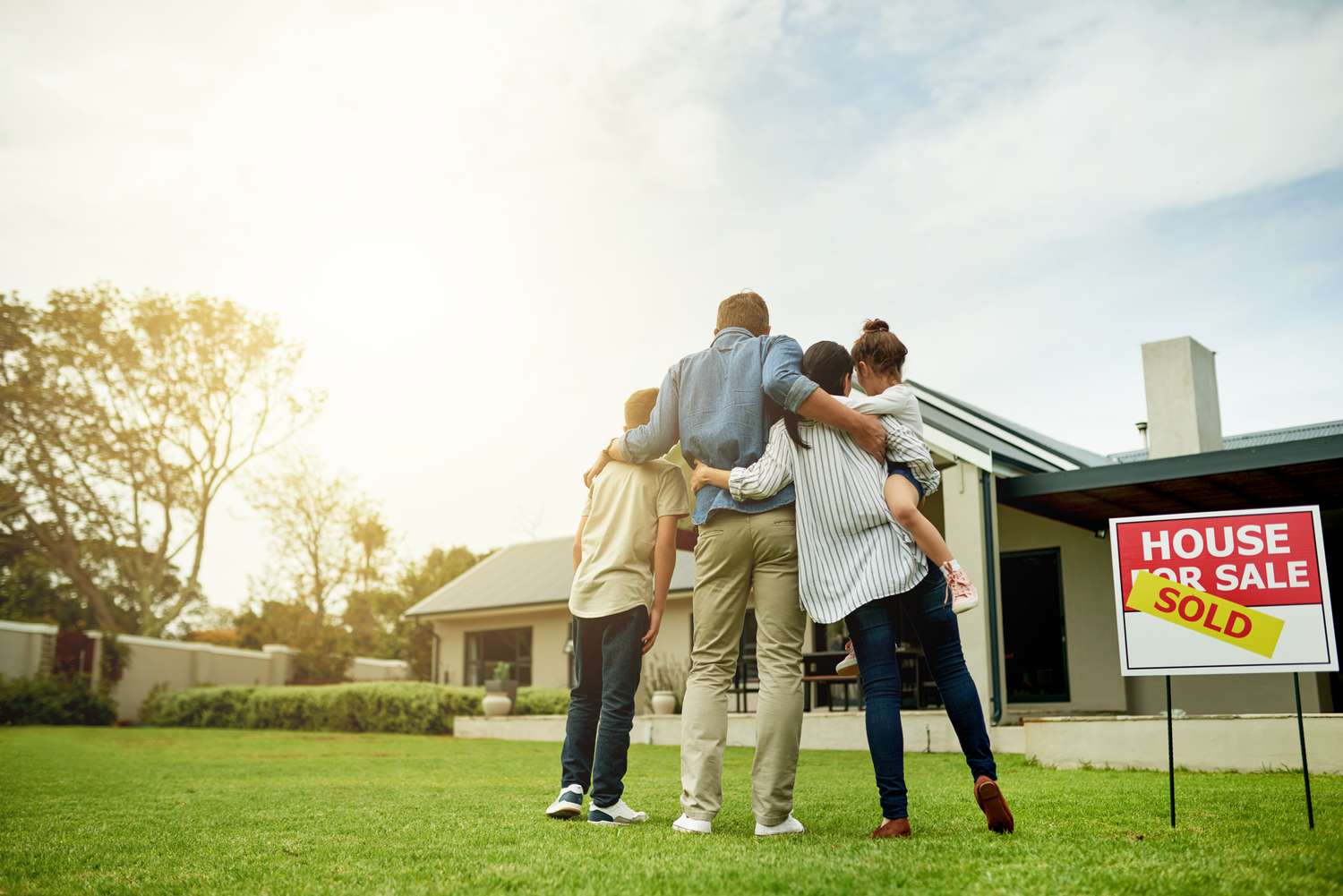 A shot of a family of four viewing their new home together.