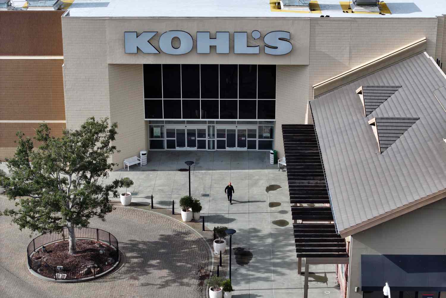  A man walks near a Kohl's.