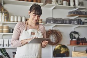Young female florist using a digital tablet in her flower shop