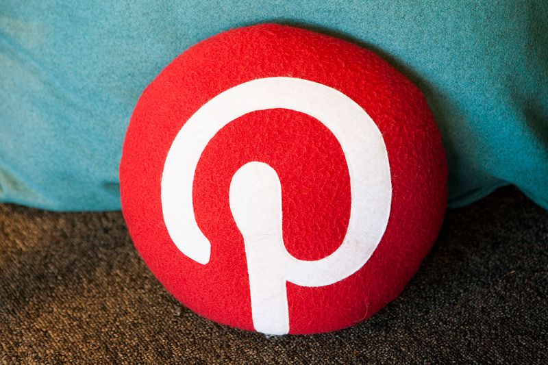 Red Pinterest logo on a pillow.