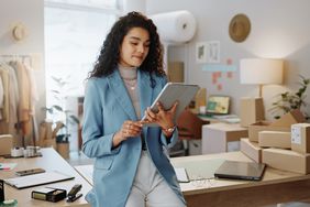 Female person or entrepreneur working on technology in storage or inventory check at retail store or shop